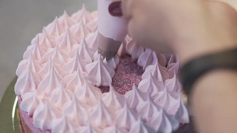 woman finishes filling top of cake with white air cream