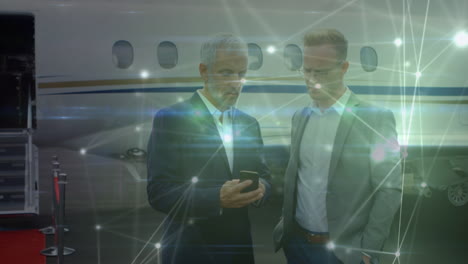 animación de la red de conexiones sobre hombres de negocios caucásicos hablando delante del avión