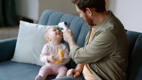 father checking baby's temperature
