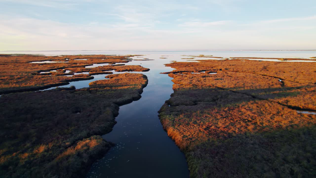 Lille flod der fører til en massiv sø omgivet af vådområder, droneoptagelse.