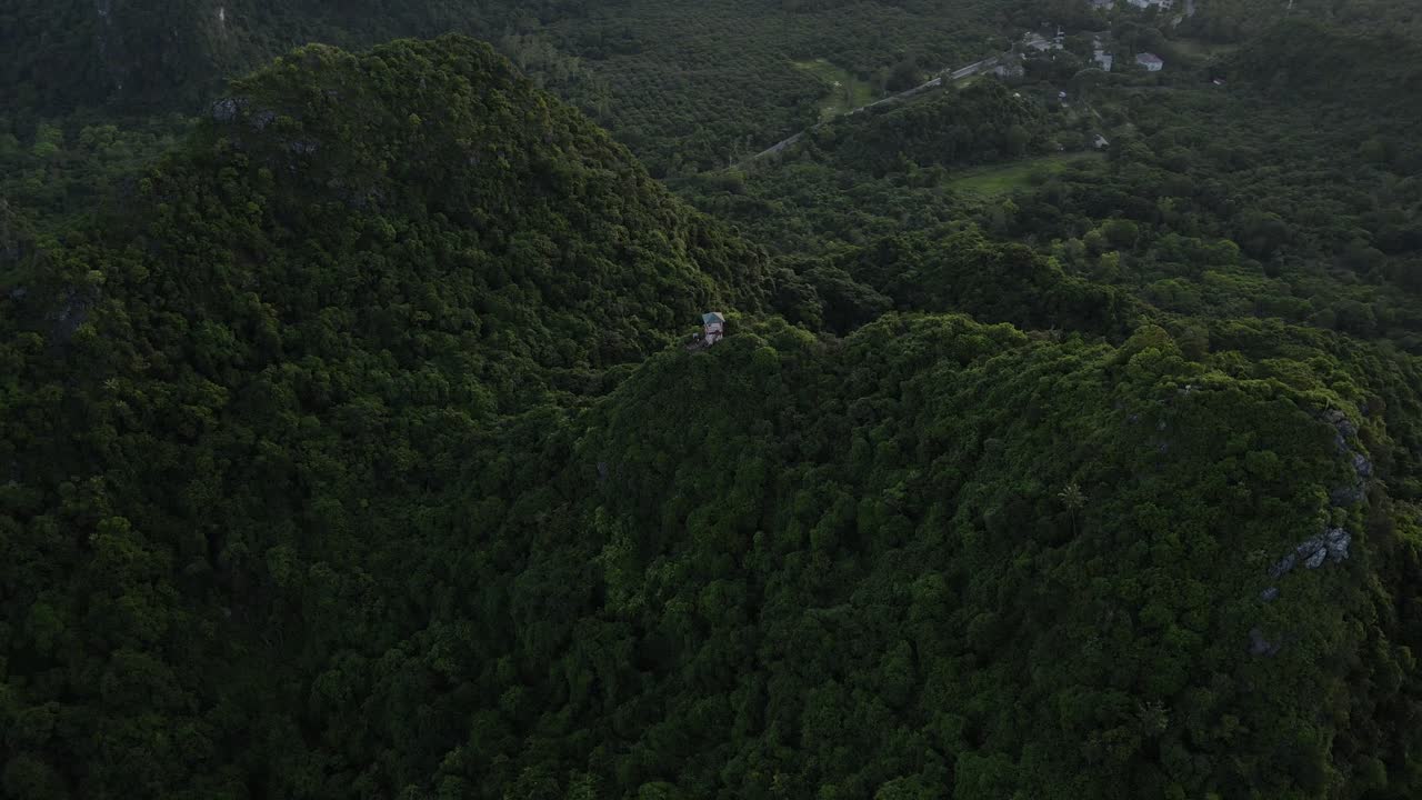 Aerial orbit over a mountain viewpoint surrounded by lush forest in Cat Ba national Park, Vietnam