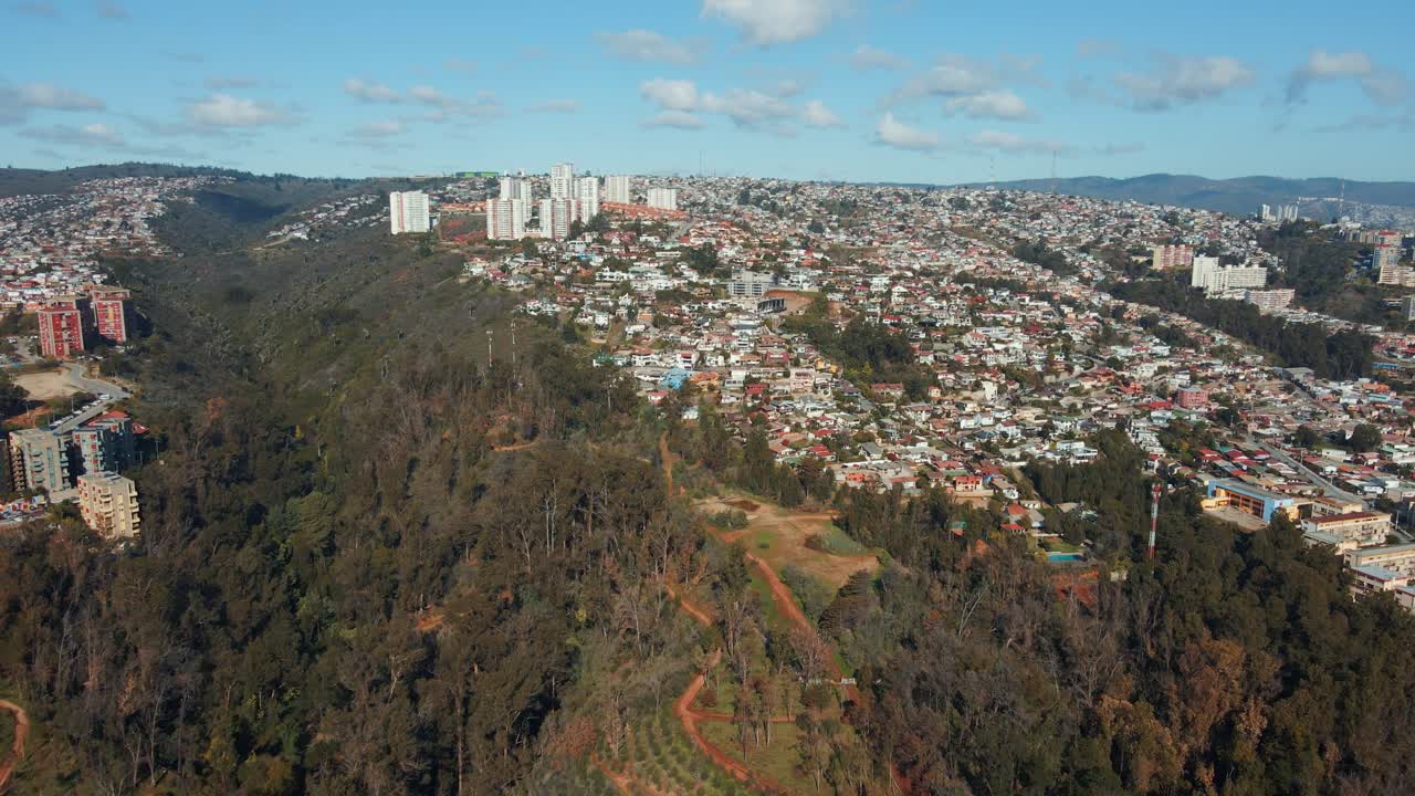carretilla aérea de los edificios de la ciudad de la ladera de viña del mar y el parque quinta vergara con bosque de árboles otoñales, chile