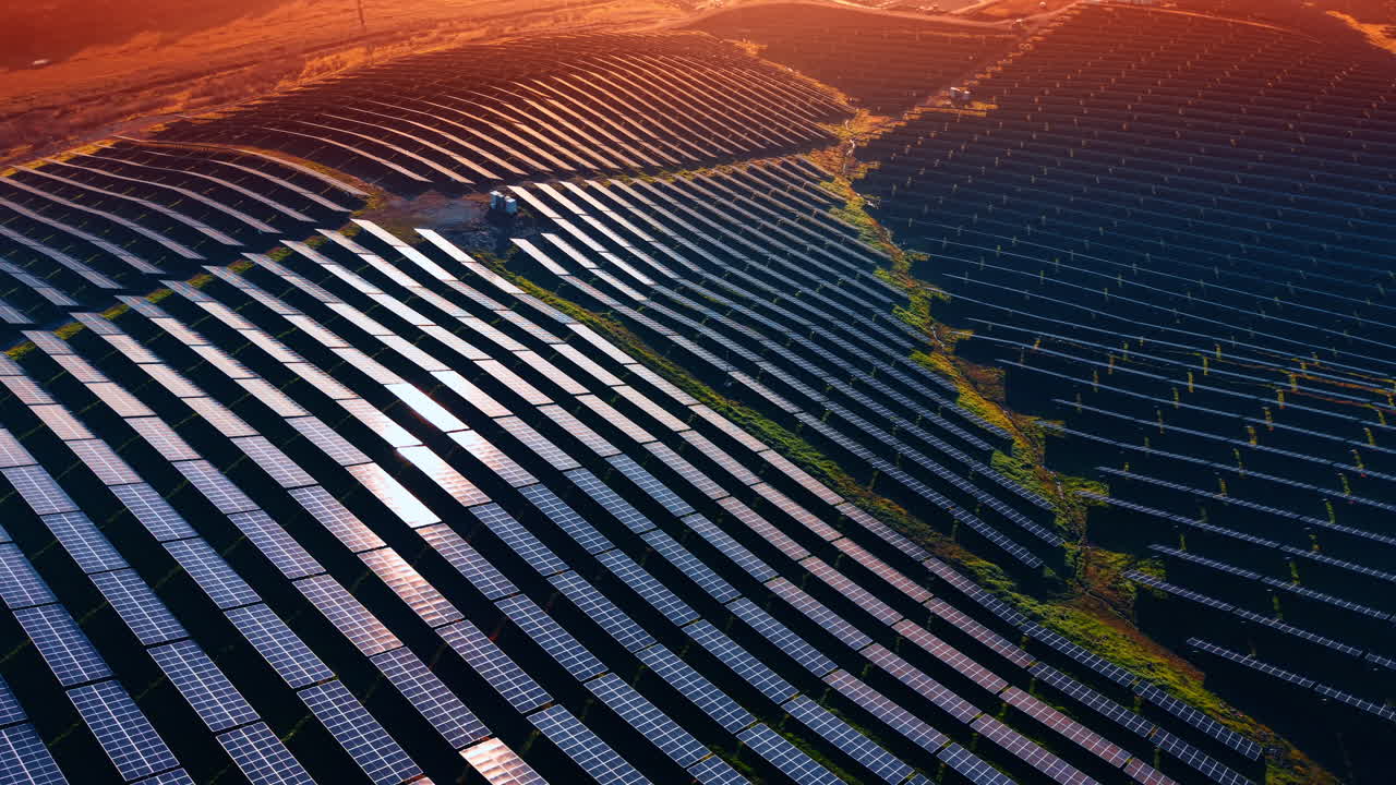 Solpaneler fylder et stort område med rækker under solen om dagen. Solpaneler dækker brede marker i et åbent område og samler sollys til energiproduktion.