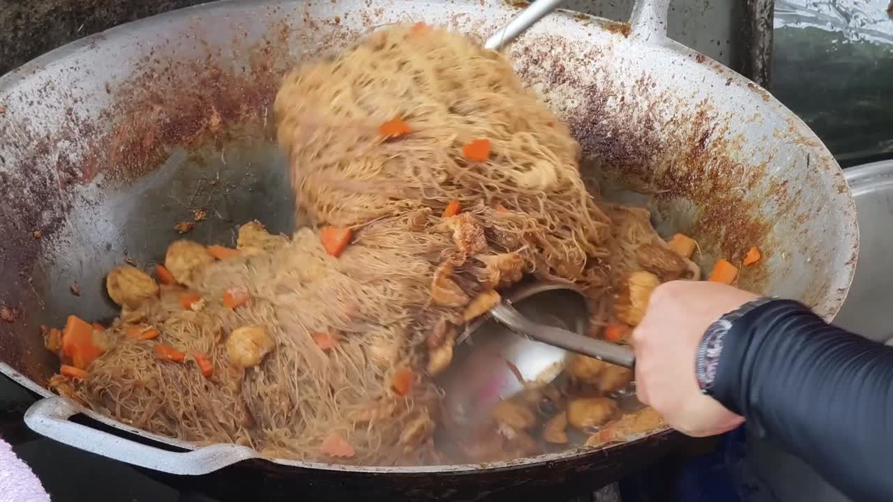 Stir-frying Noodles with Meat and Vegetables in a Wok
