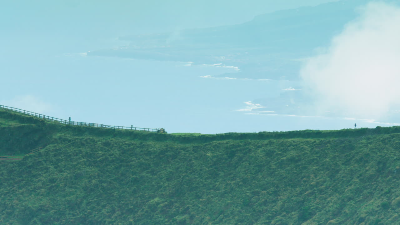피코가 배경에 있는 칼데이라 가장자리에 있는 두 조깅하는 사람의 멋진 긴 렌즈 샷