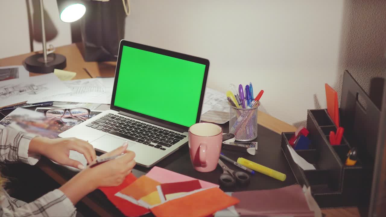 Woman working at a desk with laptop and papers