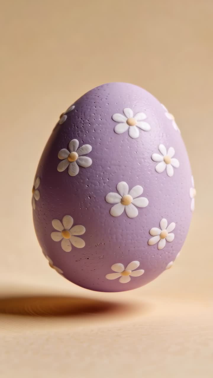 Uovo viola lavanda che ruota e ondeggia dopo l'inclinazione iniziale, rivelando motivi a margherita da esporre
