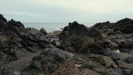 the rocky coastine at kennack sands, cornwall, england gives way to a sandy beach in a popular holiday destination