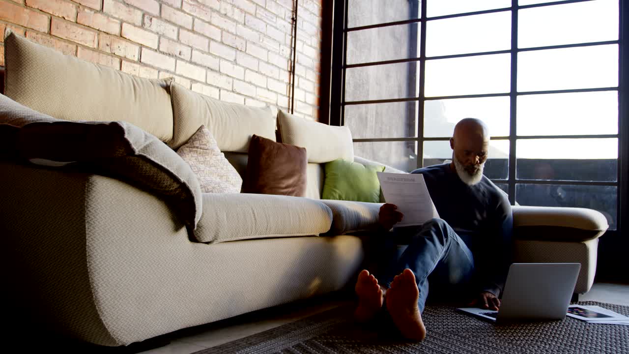 hombre mayor usando portátil en la sala de estar 4k