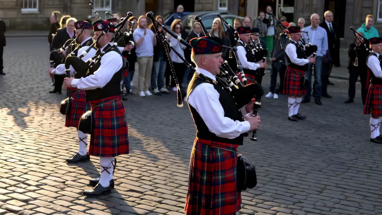Gaiteros escoceses con kilts actuando en una calle adoquinada