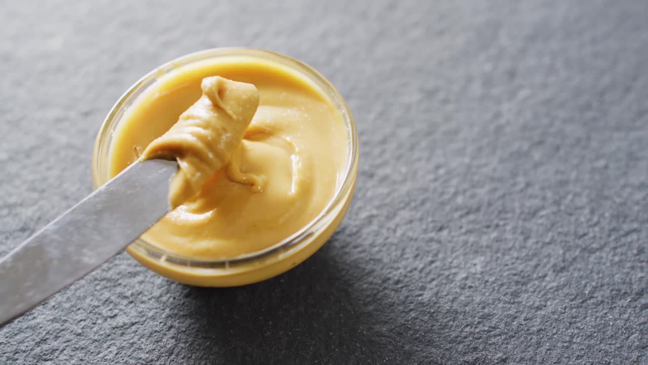 회색 배경에 땅콩 버터의 클로즈업 비디오
