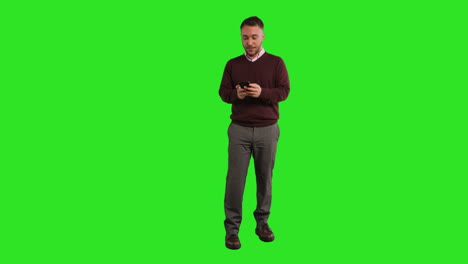 Full-Length-Studio-Portrait-Of-Mature-Male-Teacher-Or-Businessman-Standing-Against-Green-Screen-Using-Mobile-Phone-To-Message-Or-Browse-Online-2