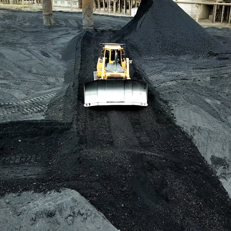 moving tractor coal around plant for processing. coal production. aerial view.