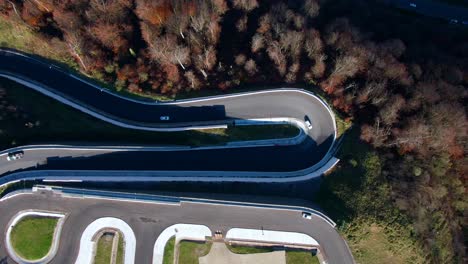 aerial view on a winding mountain road. cars drive along the mountain serpentine to meet each other. drone camera looks down