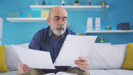 Old-man-focusing-on-paperwork-or-documents.