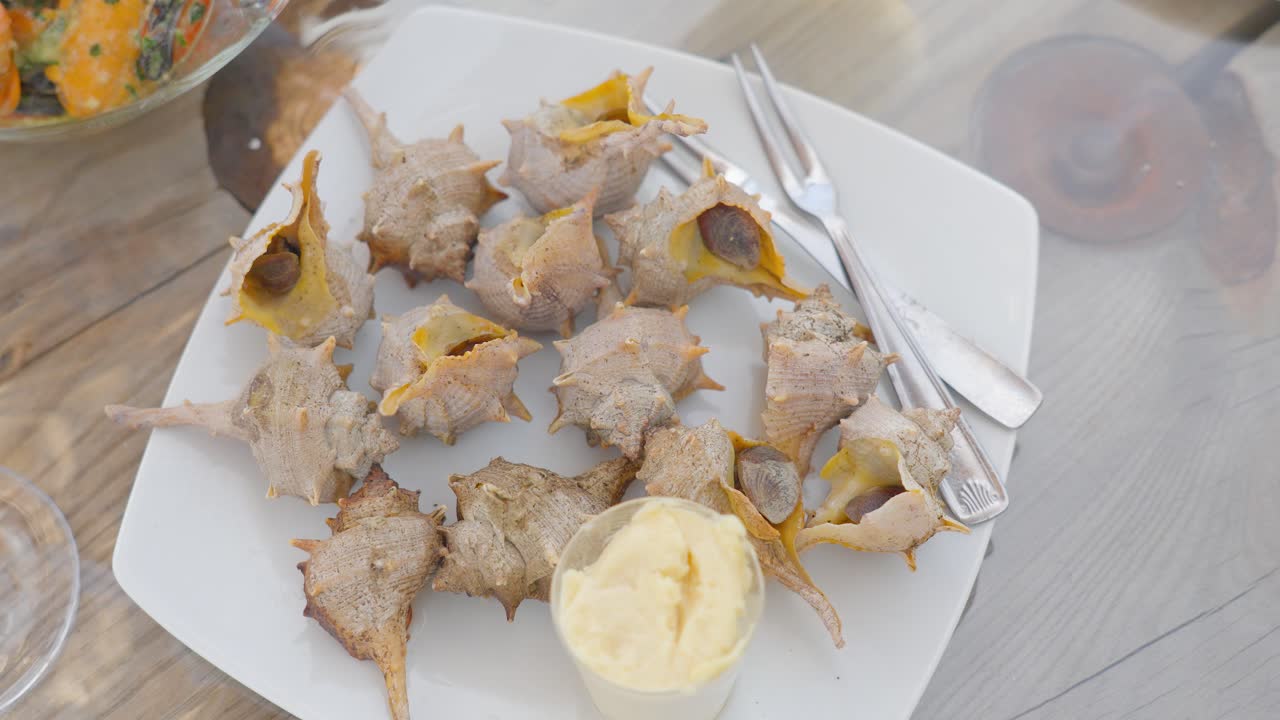 맛있는 소스와 함께 무렉스 브란다리스 (murex brandaris) 를 넣은 접시의 위아래  ⁇