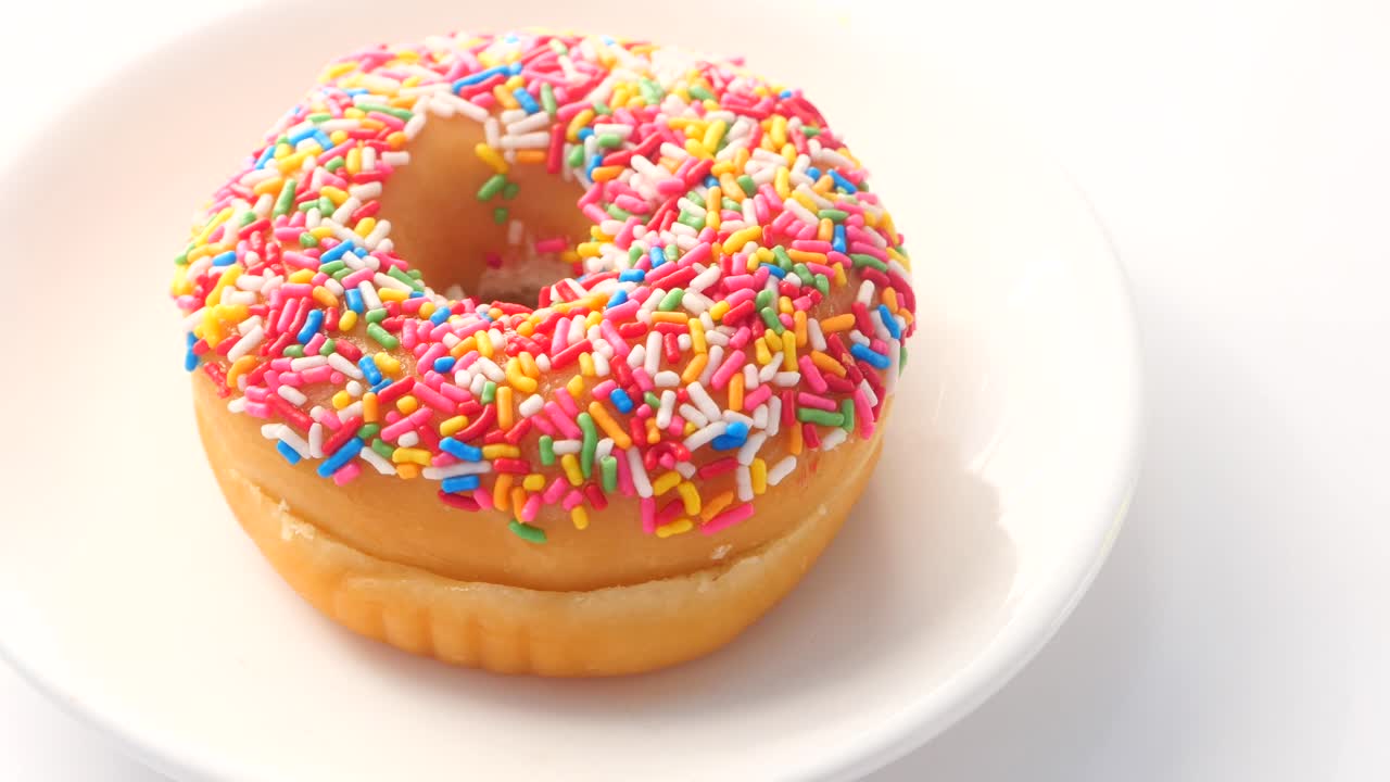 rosquilla salpicada de colores en un plato blanco