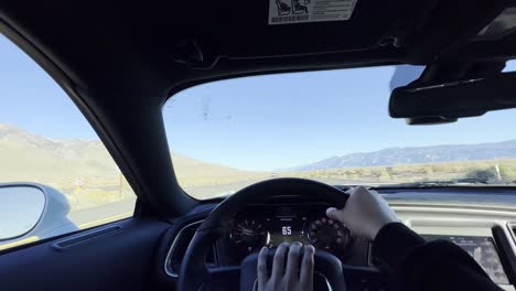 video en primera persona conduciendo un auto de lujo en una carretera vacía