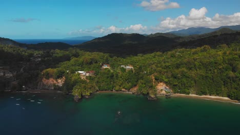 Amazing-aerial-of-a-fishing-village-and-fishing-boats-out-at-sea-near-cliff-side-beaches