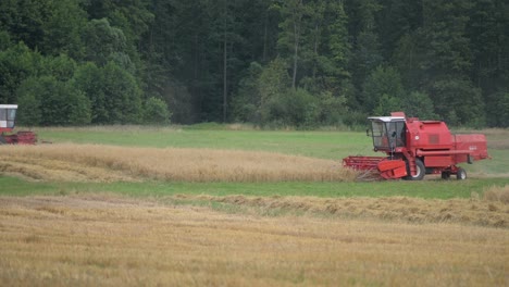 Dos-Máquinas-Tractoras-De-Cosecha-Rojas-Que-Trabajan-En-El-Campo-De-La-Granja-Orgánica