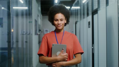 woman holding tablet in office corridor