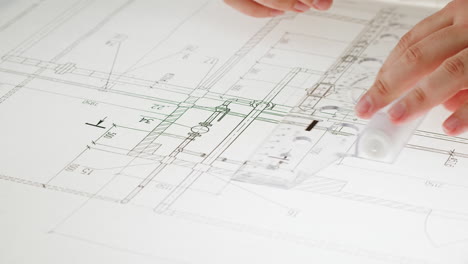 close-up of hands drawing on a blueprint