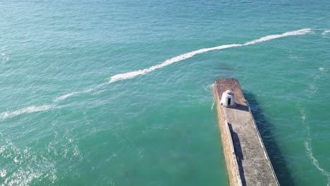 Aerial-View-Of-The-Monkey-Hut,-A-Historical-Landmark-At-The-Celtic-Sea-In-Portreath,-Cornwall