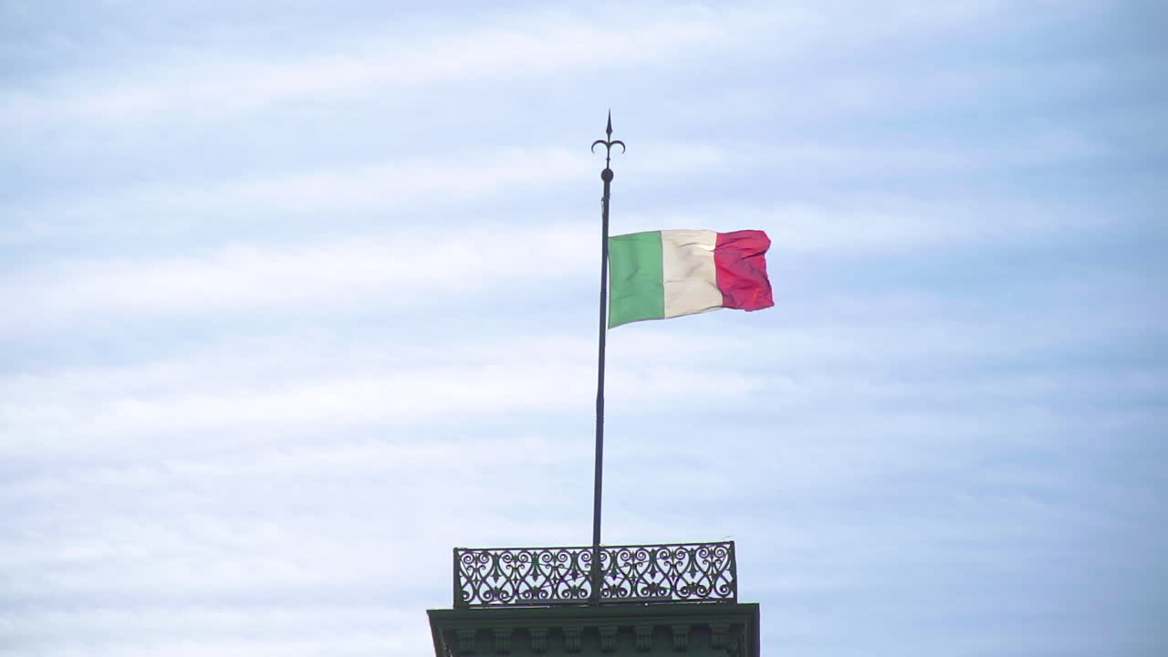 Ripresa al rallentatore della bandiera italiana che sventola su un'asta in cima a un edificio in Piazza Unità d'Italia a Trieste, Italia