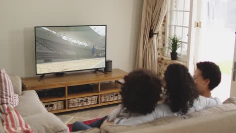 composite of happy family sitting at home together watching long jump athletics on tv