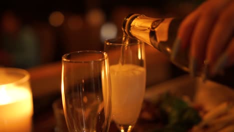 close up - new year's eve - pouring a glass of champagne at a luxury restaurant