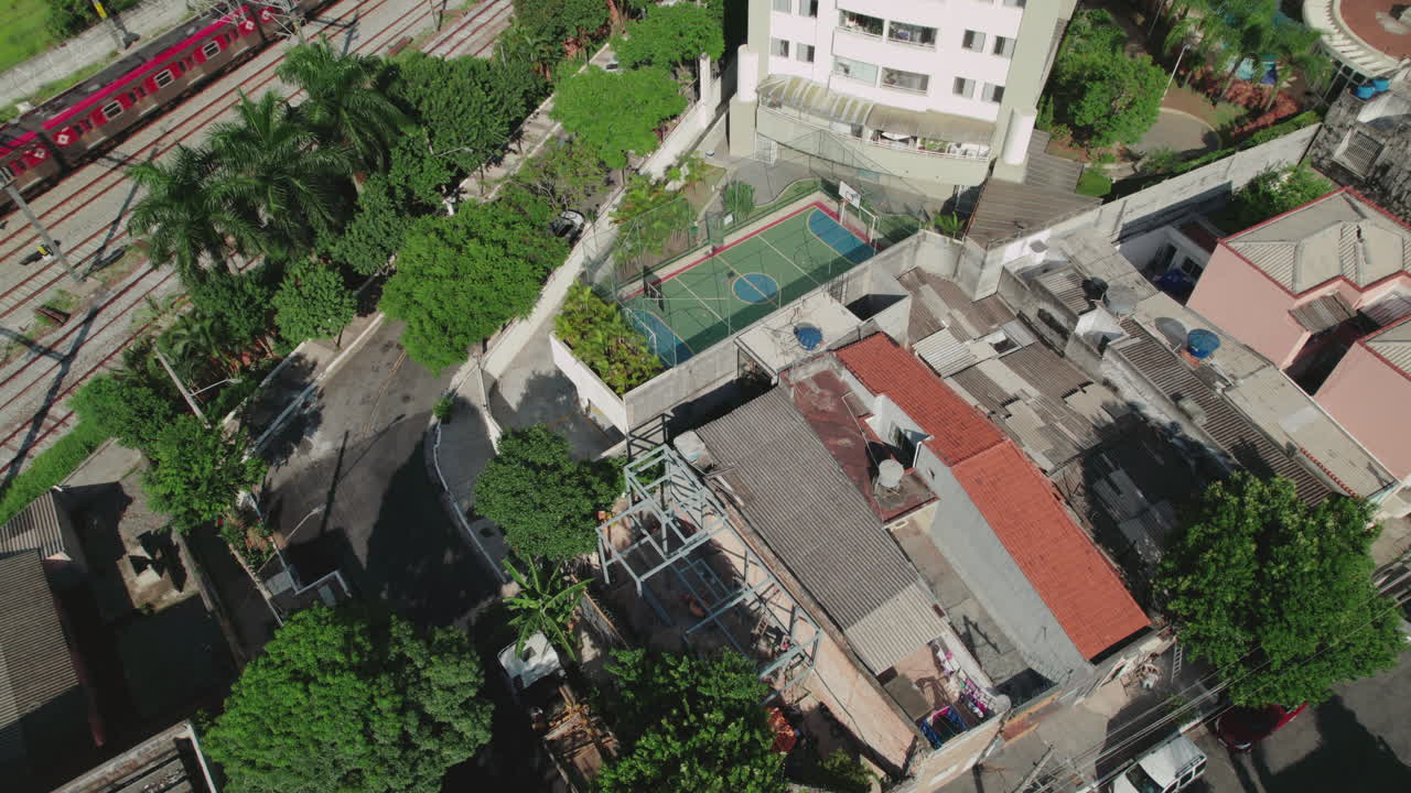 Aerial View of Urban Landscape with Train Tracks, Residential Buildings, and Green Spaces