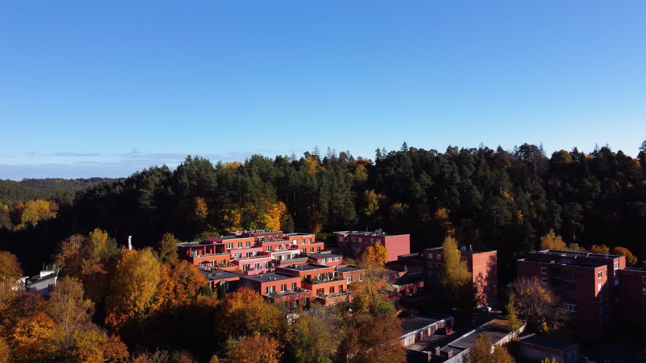 AERIAL Ascending Shot of a Residential Area in Antakalnis District, Vilnius, Lithuania deep within an Autumn Forest