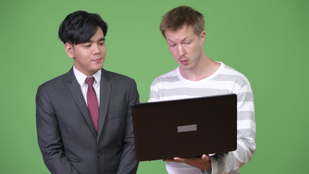 젊은 잘생긴 아시아 사업가와 젊은 스칸디나비아 사업가가 함께 일하고 있습니다.