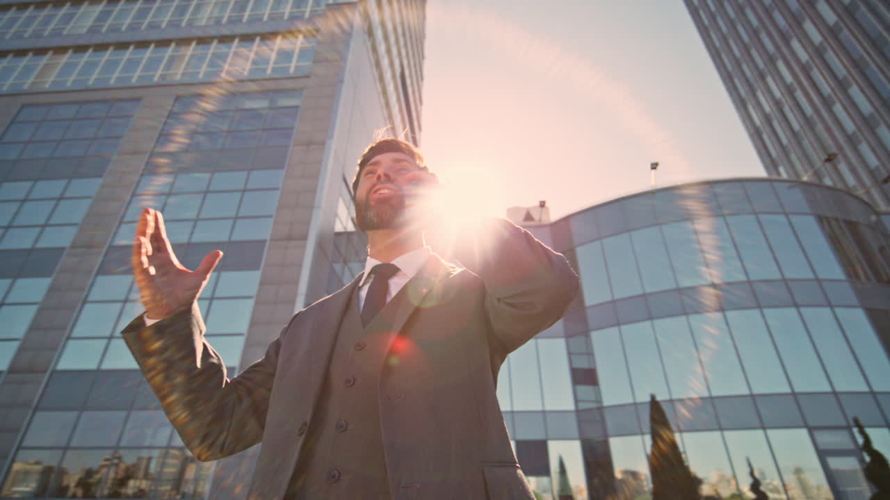 excitado hombre de negocios llamando por teléfono en la calle soleada de cerca.