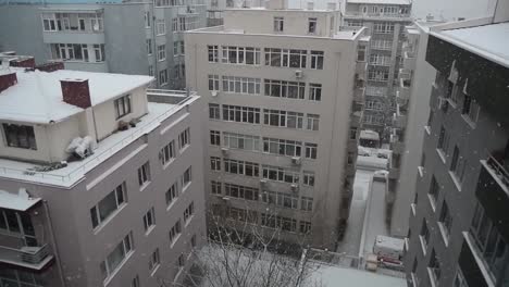 a big snow storm, called filomena, falls over the large buildings in the city.aerial view. beautifully snow falling shot over city in evening time.