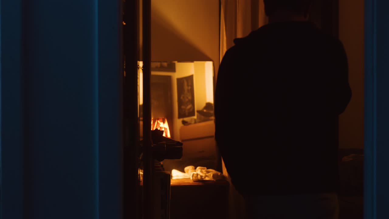 Man walks through apartment then takes off his shirt