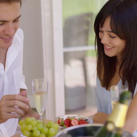 couple sipping wine and eating fruit