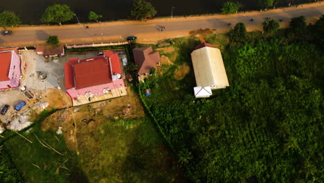 Aerial-tilt-shot-over-a-road-on-the-coast-of-Lac-Muncipal-in-Ebolowa,-Cameroon