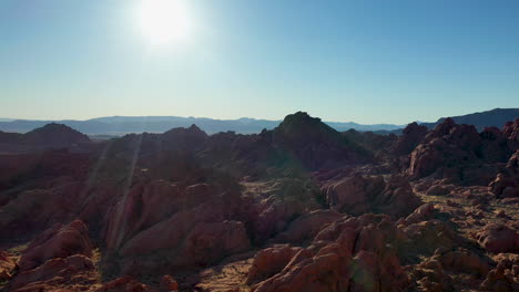 valley of fire state park usa. beautiful fast revealing aerial shot from the dusty floor and sandstone hills, revealing the strong sunshine