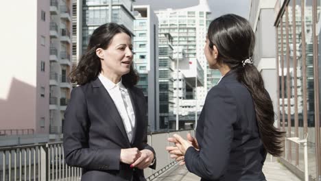 smiling businesswomen talking on street