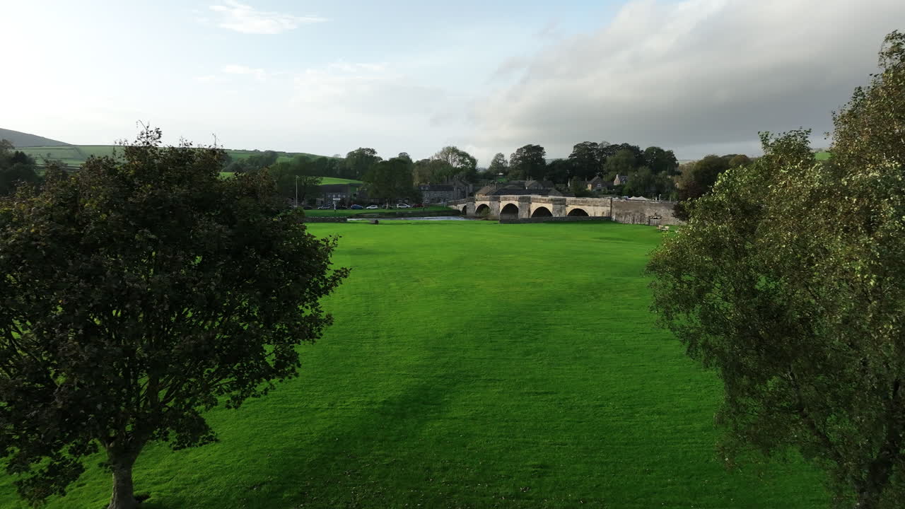 요크셔에서 아름다운  ⁇ 은 날, 배경에 태양이 서서 밝은 다리를 향해 두 나무 사이에 날아