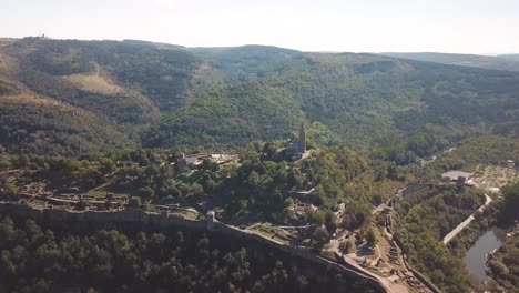 Forward,-crane-down-drone-shot-over-a-hill-with-an-archeological-site-in-Bulgaria