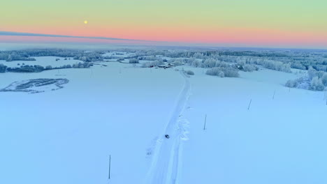 beautiful snowy winter landscape at sunset in latvia with fields and forests