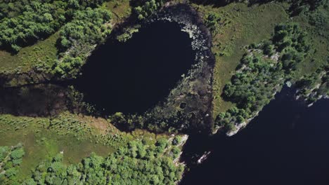 Vista-De-Drones-De-Arriba-Hacia-Abajo-En-Un-Lago-Remoto-Rodeado-De-Bosques-Y-árboles-Hb14