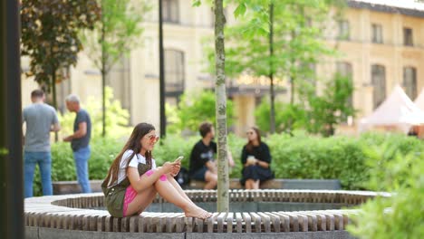 mujer usando el teléfono en un parque urbano