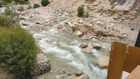 indus river flowing below a bridge with buddhist prayer flags on leh hanle route in ladakh india