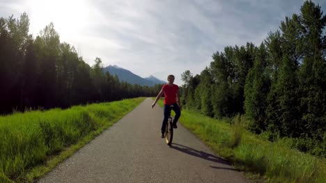 woman riding unicycle on countryside road 4k