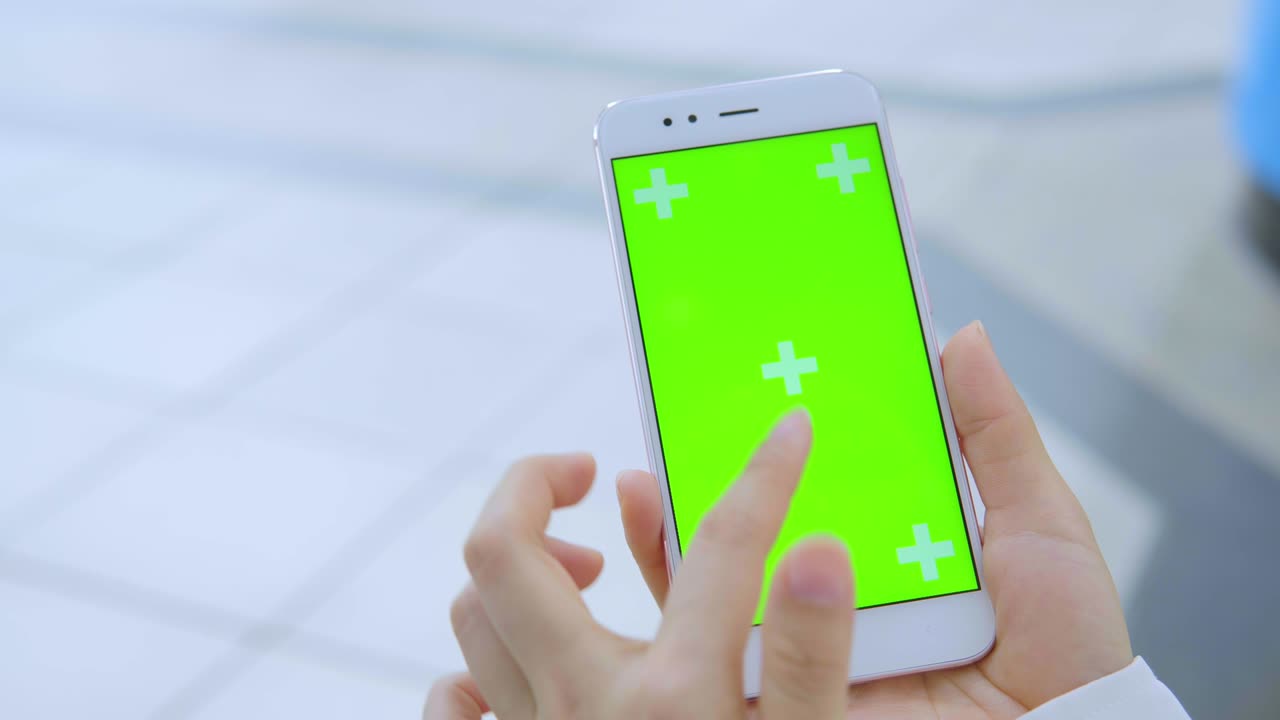 Business woman using smartphone with green screen on the street