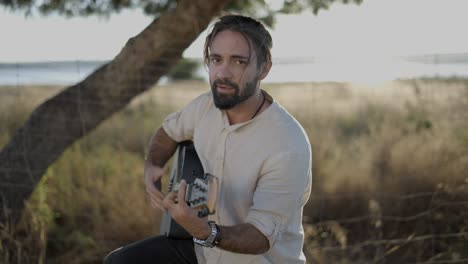 hombre tocando la guitarra acústica al aire libre