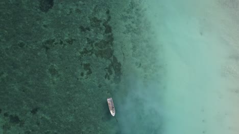 empty wooden boat anchored off coast of zanzibar. aerial birdseye, static
